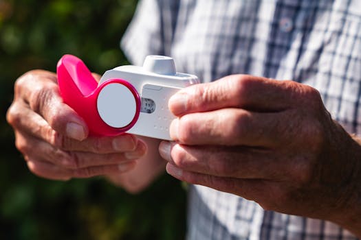 Close-up of senior hands holding an inhaler outdoors, showcasing health and respiratory care.